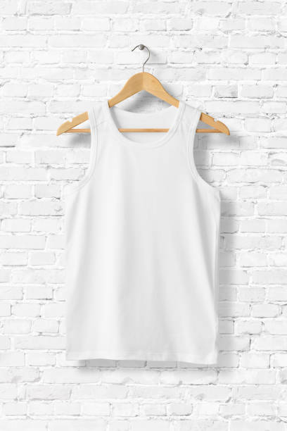 istock White Tank Top Shirt Mock-up hanging on white brick wall, front view. 931240780