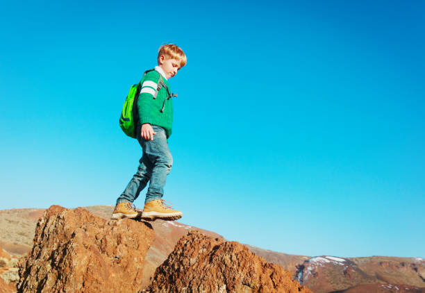istock little boy with backpack hiking in mountains 931240874