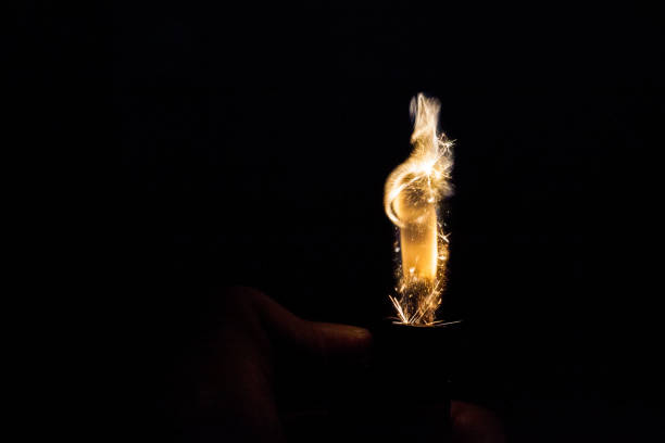istock Close up view of real sparking light from lighter in dark black background 931245698