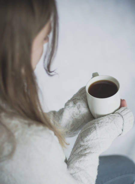 istock Girl holding a coffee cup in cozy sweater 931251410