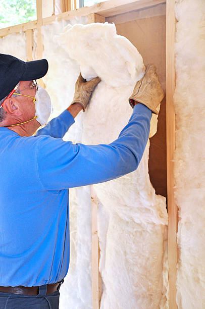 Man installing fiberglass insulation stock photo