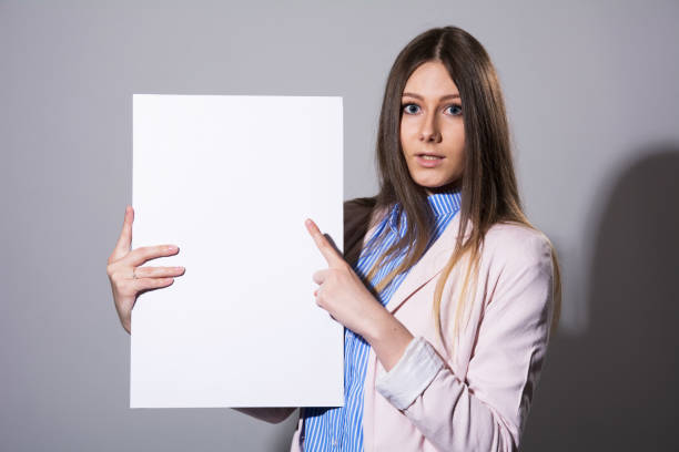 istock Young beautiful woman pointing at a blank sheet 931261822