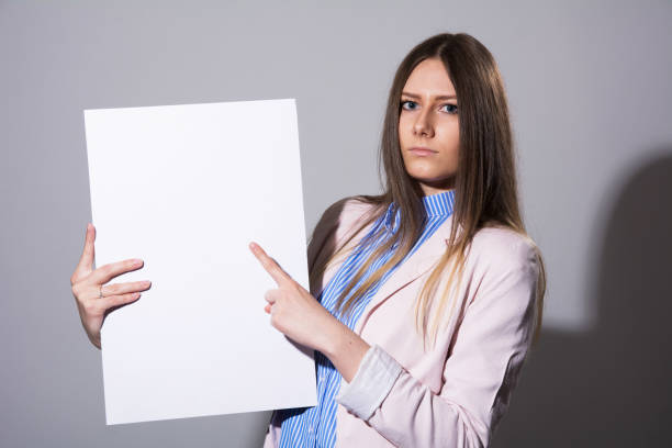 istock Young serious woman pointing at white sheet 931261890