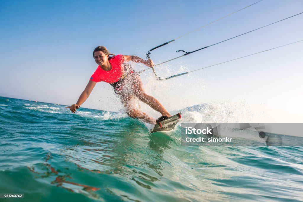 Woman doing kitesurfing Woman doing kitesurfing on sea and smiling. Kiteboarding Stock Photo