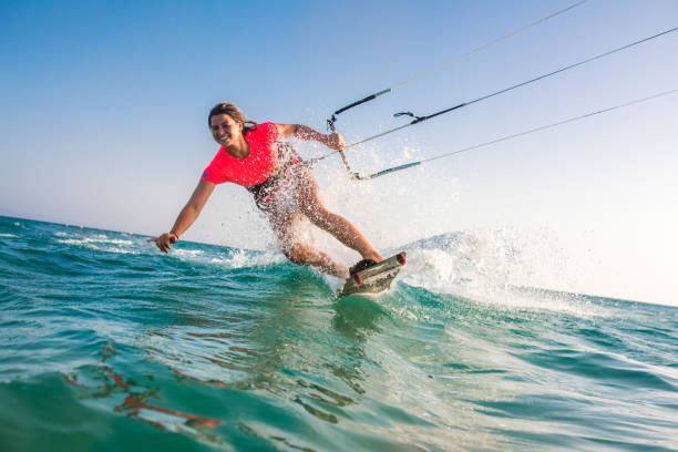 Woman doing kitesurfing Woman doing kitesurfing on sea and smiling. aquatic sport stock pictures, royalty-free photos & images