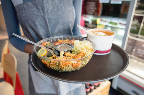 istock Unrecognizable waitress holding a tray with a pasta salad and a soup 931275542
