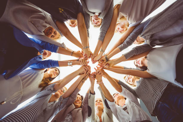 équipe féminine. groupe de femmes main dans la main - loyalty business solidarity human hand photos et images de collection