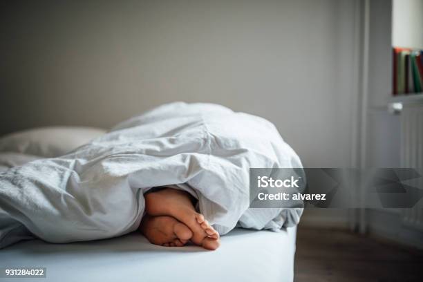 Low Section Of Young Woman Sleeping In Bed Stock Photo - Download Image Now - Sleeping, Bed - Furniture, Women