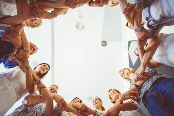 istock Group of women stnading in circle and holding hands 931284044