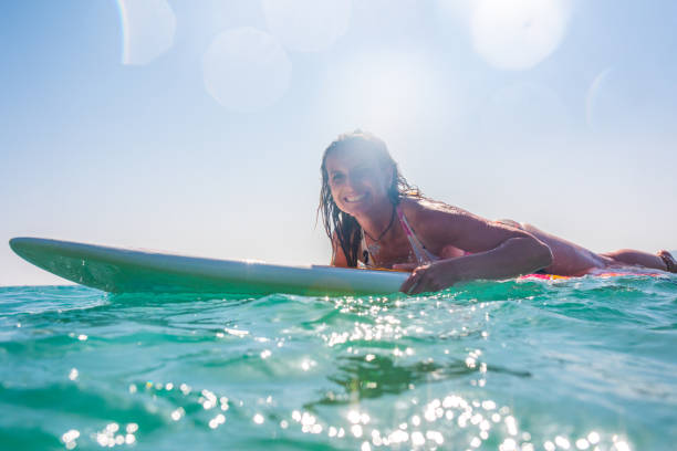 istock Woman lying on surfboard in sea 931289836