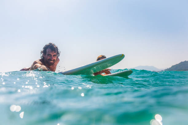 istock Young couple lying on surfboard in sea 931289838