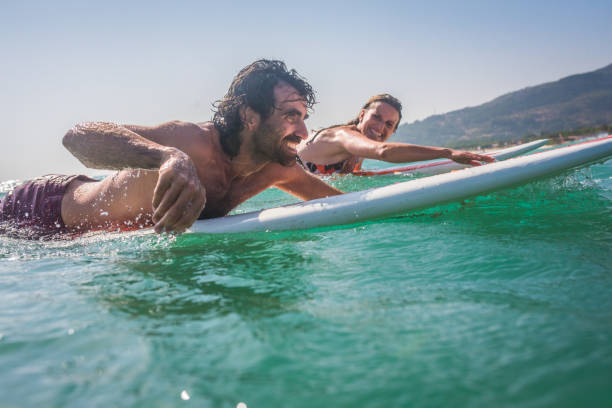 istock Young couple lying on surfboard in sea 931289844