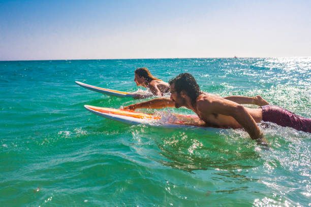 istock Young couple lying on surfboard in sea 931289874