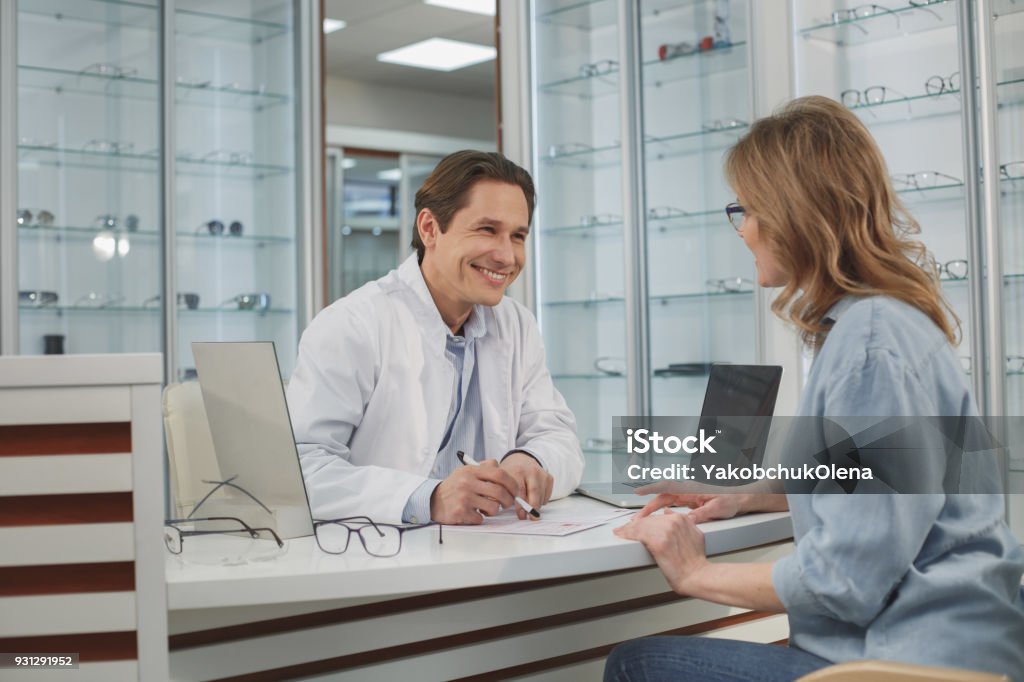 Doctor alegre hablar con el cliente - Foto de stock de Optometrista libre de derechos