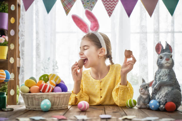 bambino sta mangiando uova di cioccolato - easter easter egg child chocolate foto e immagini stock