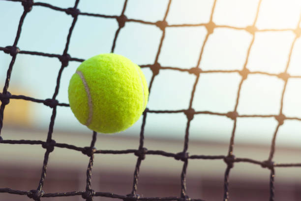 istock Close up tennis ball hitting to net on blur background 931308582