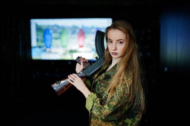 istock Military girl in camouflage on shooting range. 931317040