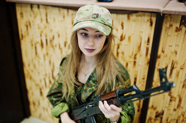 istock Military girl in camouflage on shooting range. 931317544