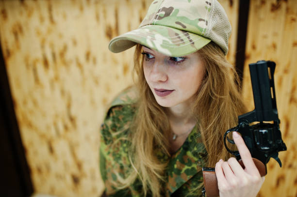 istock Military girl in camouflage on shooting range. 931317820
