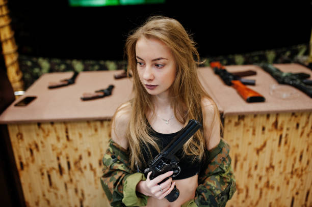 istock Military girl in camouflage on shooting range. 931318214