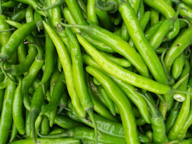 istock Green hot chili peppers on white backgrounds 931326302