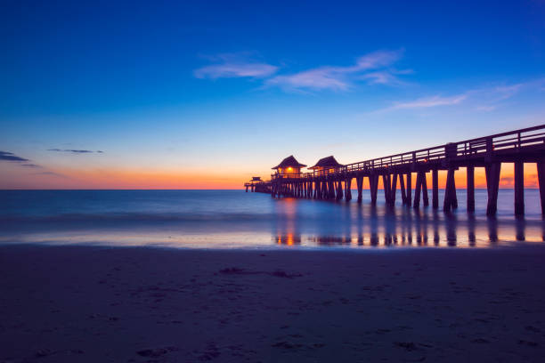 hora del crepúsculo en el muelle de nápoles en nápoles, florida - florida naples florida pier beach fotografías e imágenes de stock