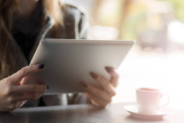 istock Young woman sitting at cafe table with digital tablet 931332262