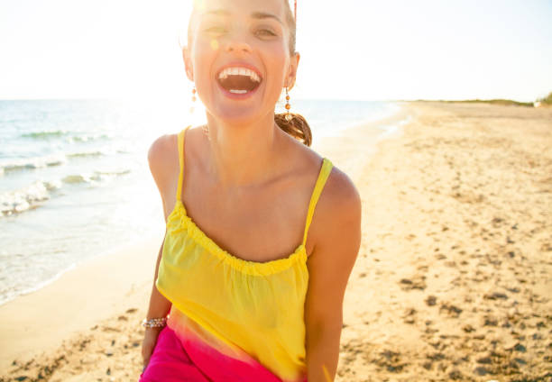 istock smiling young woman on beach in evening having fun time 931333052