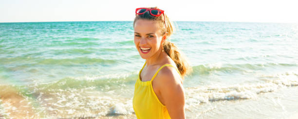 istock smiling young woman on seacoast in evening having fun time 931333322