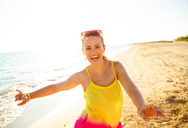 istock smiling modern woman on beach in evening having fun time 931333580