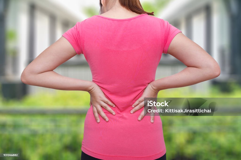 Female athlete lower back painful injury. Sporty woman backache and injury Adult Stock Photo