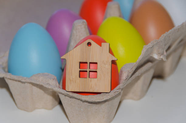 пасхальные окрашенные яйца и деревянная игрушка дома, фон - pasch стоковые фото и изображения