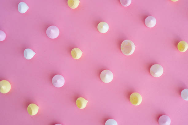 istock Multicolored meringue arranged in an even row on a pink background 931347252