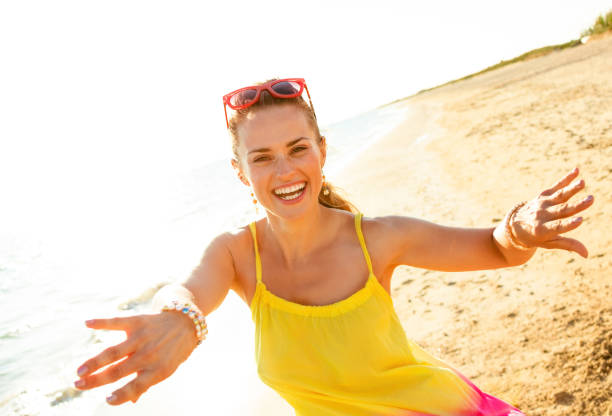 Colorful and wonderfully cheerful mood. smiling young woman in colorful dress on the beach in the evening having fun time