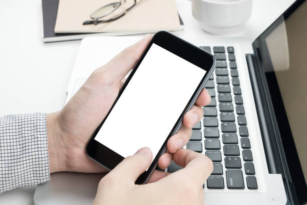 istock Business man is holding a smartphone with white blank screen. 931358334