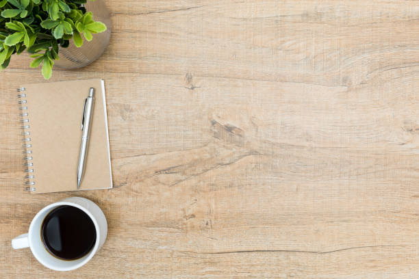 istock Wood office desk table with notebook, cup of coffee. Top view with copy space, flat lay. 931364456