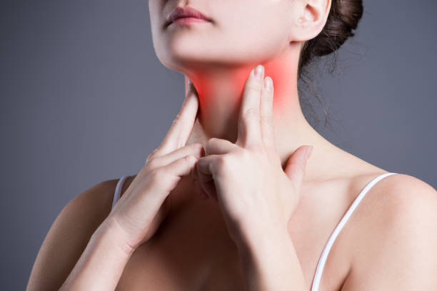 Sore throat, woman with pain in neck, gray background stock photo