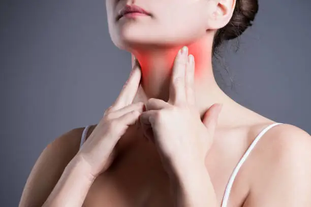 Photo of Sore throat, woman with pain in neck, gray background