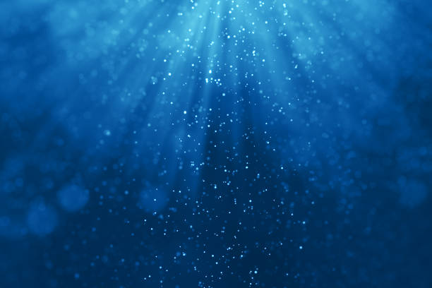 istock deep blue ocean waves from underwater background with particles flowing movement, light rays shining 931384922