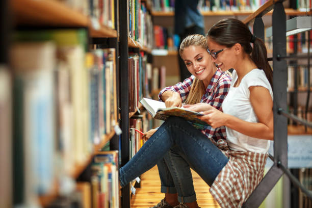 istock Two female students read and learns by the book shelf at the library. 931385554