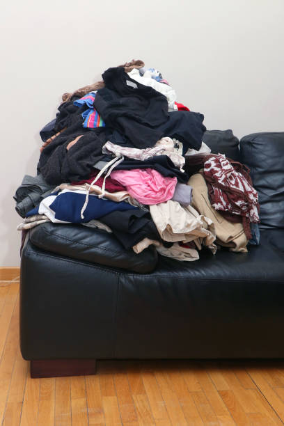 istock Messy clothes pile on leather couch 931388600