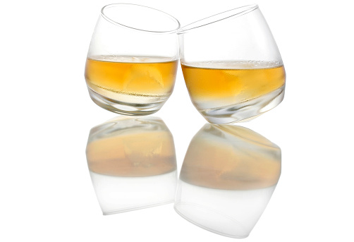 Two touching whiskey glasses with reflections