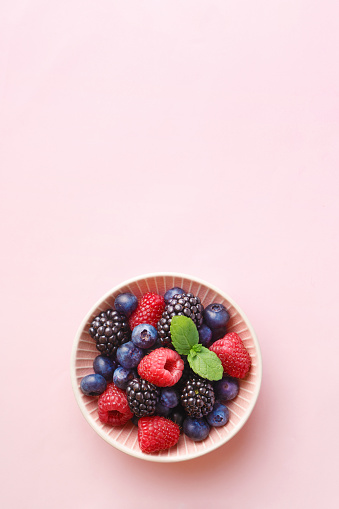 Tazón de fuente de frutas baya (frambuesa, arándano, zarzamora) sobre un fondo pastel. Vista superior. Copia espacio photo