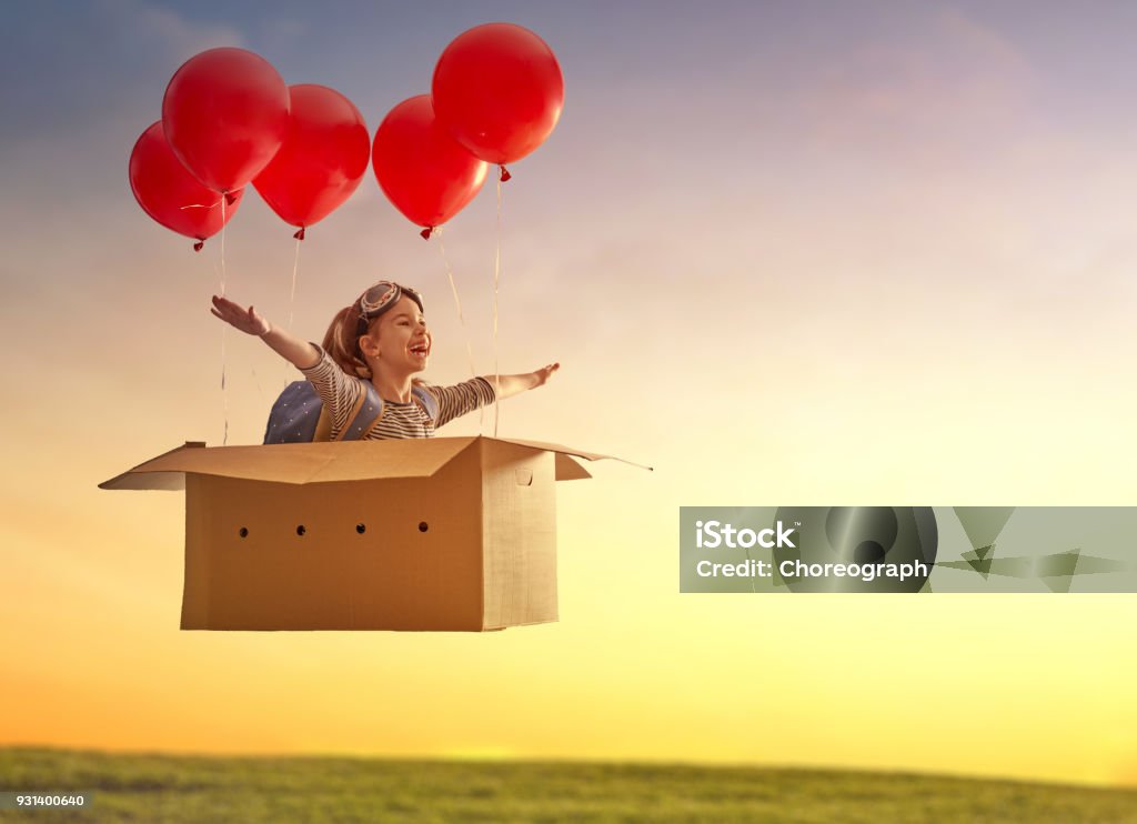 Dreams of travel Dreams of travel! Child is flying in cardboard box with air balloons. Child Stock Photo