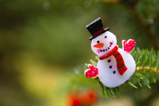 istock Snowman, Christmas ornament hanging on a pine tree outdoors 931409124