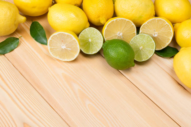 istock on a light wooden table, sliced lemons and lime 931409474