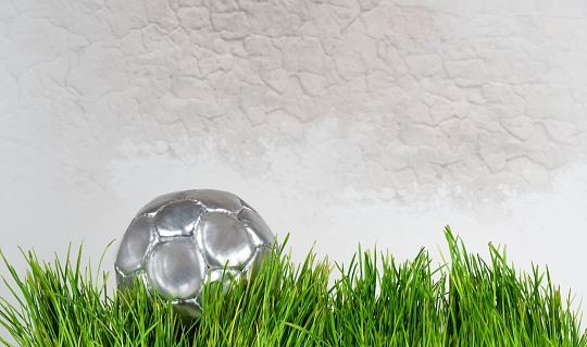 silvery decorative soccer ball on brick wall background
