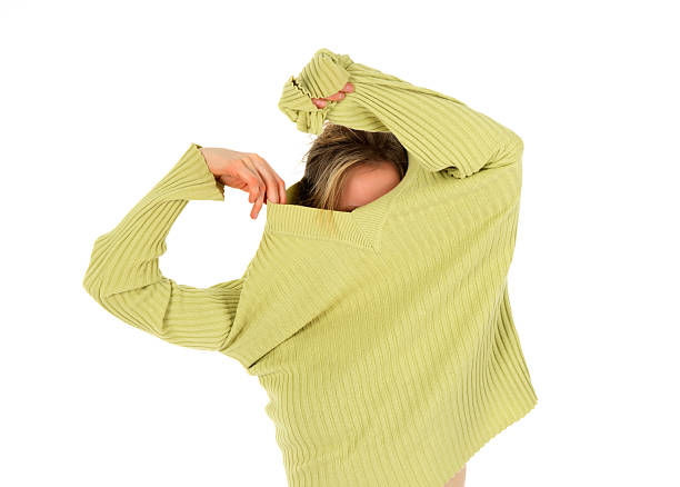 Funny girl takes off a green sweater stock photo