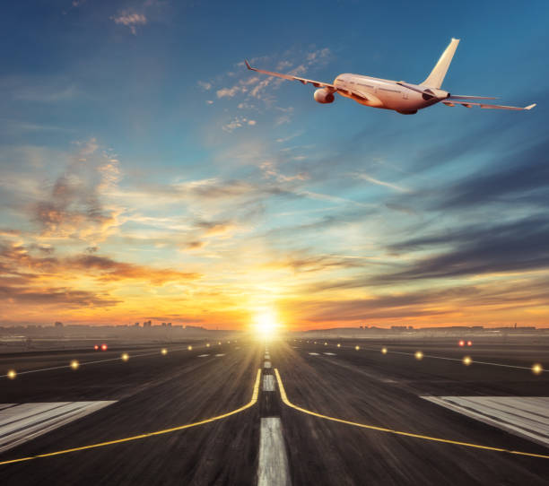 istock Commercial airplane flying above runway in sunset light. 931412476