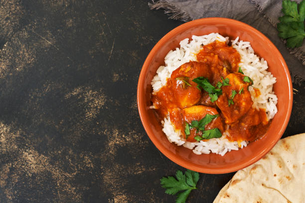 Chicken korma with a spicy sauce over white rice.Traditional Indian dish on a rustic background. Top view, copy space. Chicken korma with a spicy sauce over white rice.Traditional Indian dish on a rustic background. Top view, copy space savory food photos stock pictures, royalty-free photos & images